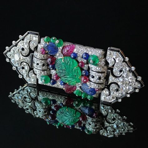 UNE BROCHE ART DÉCO MULTI-GEMME ET DIAMANT 'TUTTI FRUTTI', CARTIER Émeraudes sculptées, perles émeraude, rubis et saphir, plaques d'onyx, diamants taille ancienne, platine et or, 3 3/8 ins., Vers 1930, signées Cartier @ Christie's Maharajas & Mughal Magnificence New York, 19 juin 2019