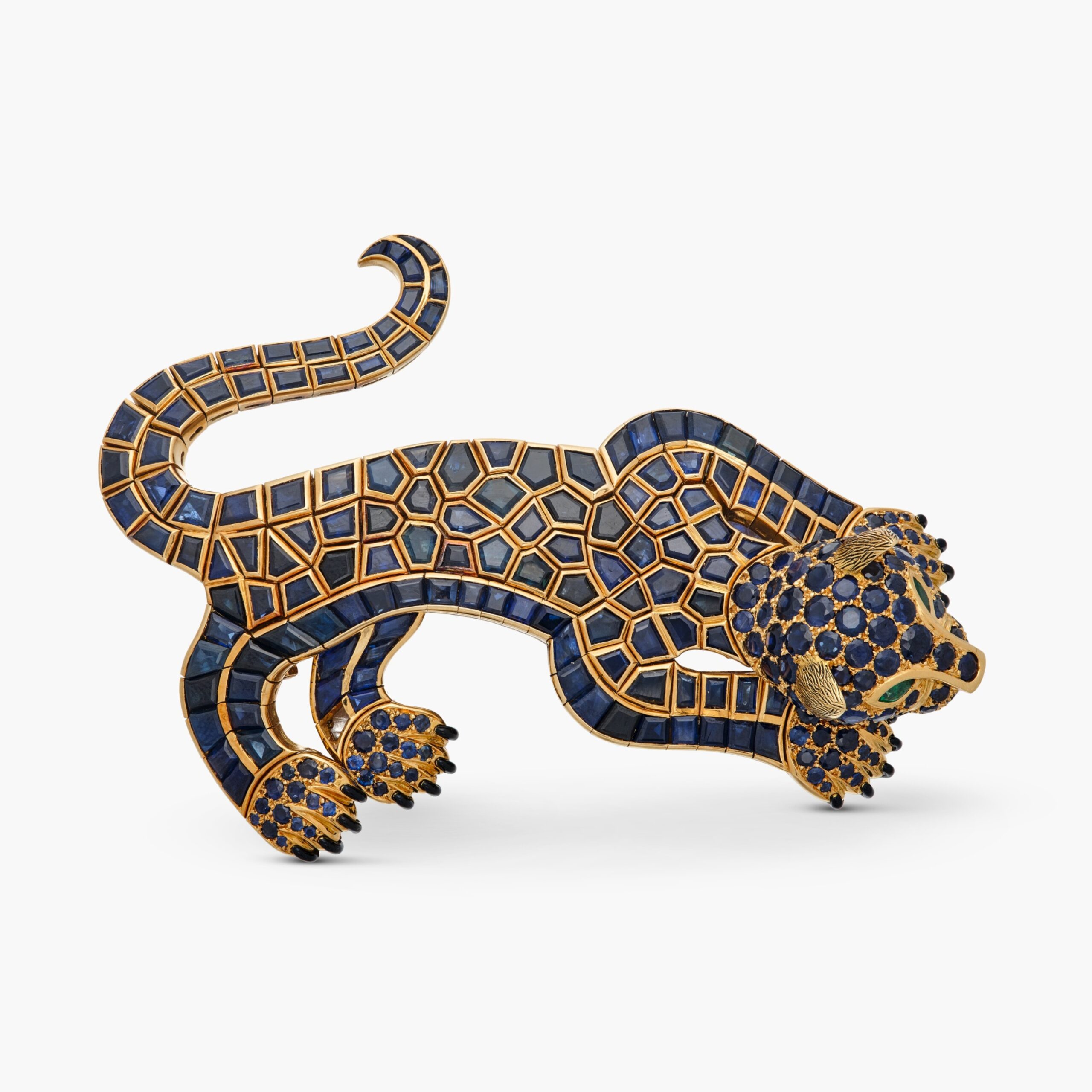 Clip-broche articulé René Boivin figurant un léopard, en or serti de saphirs ronds et calibrés, les yeux ornés d’émeraudes de taille marquise et les griffes soulignées d’émail noir. Signé René Boivin – Paris, portant les poinçons français de titre et le poinçon d’atelier de la Société Profillet, 1967. Écrin signé.Le certificat d’authenticité René Boivin no 202510YYP, daté du 24 octobre 2025, atteste que cette pièce fut réalisée en février 1967 d’après un dessin de Juliette Moutard.Collection patrimoniale René Boivin
